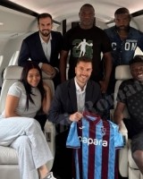 奥纳纳与家人、经纪人在飞机上合影，展示特拉布宗体育球衣